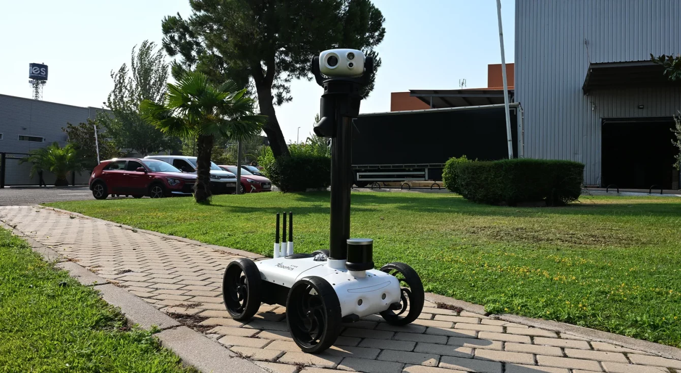 Robot Watchbot de Star Robotics patrullando de día el camino perimetral de una instalación industrial