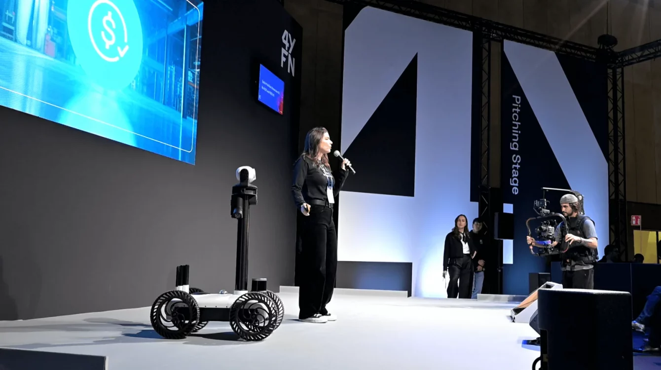 The Watchbot robot on the pitching stage at Mobile World Congress 2025 during a presentation